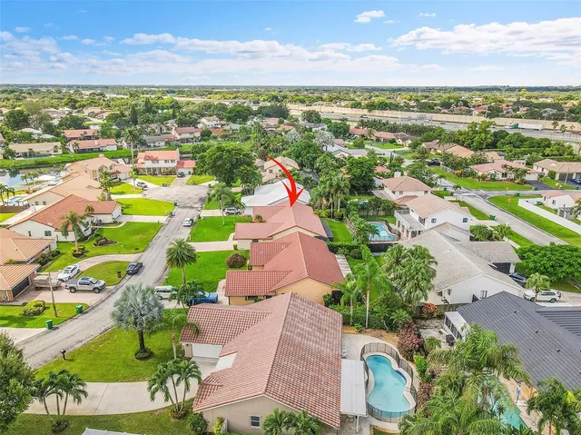 an aerial view of residential houses with outdoor space and swimming pool
