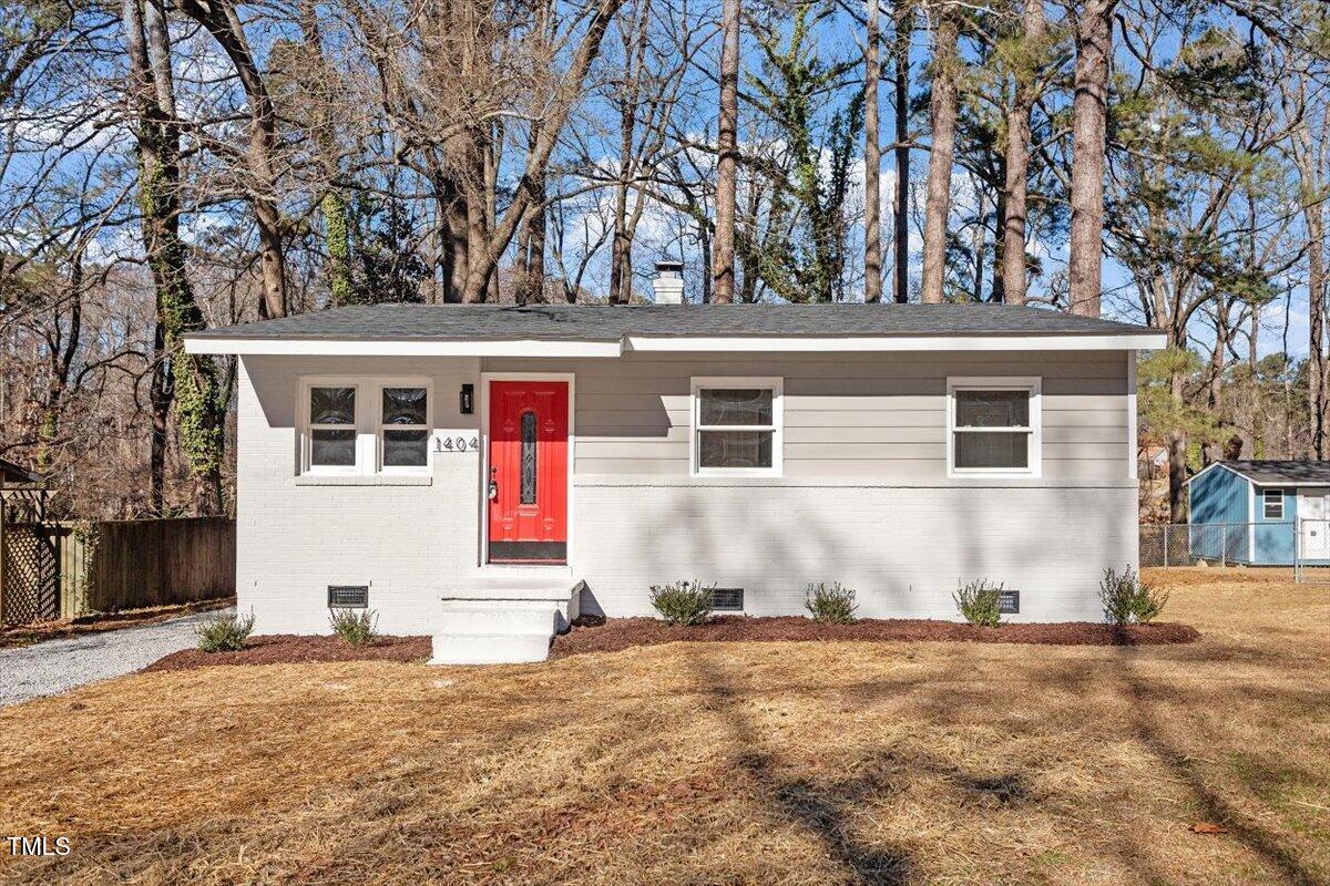1404 Valley Road Garner, NC 27529 - Photo 2 of 29 a view of a white house with a large tree and a yard