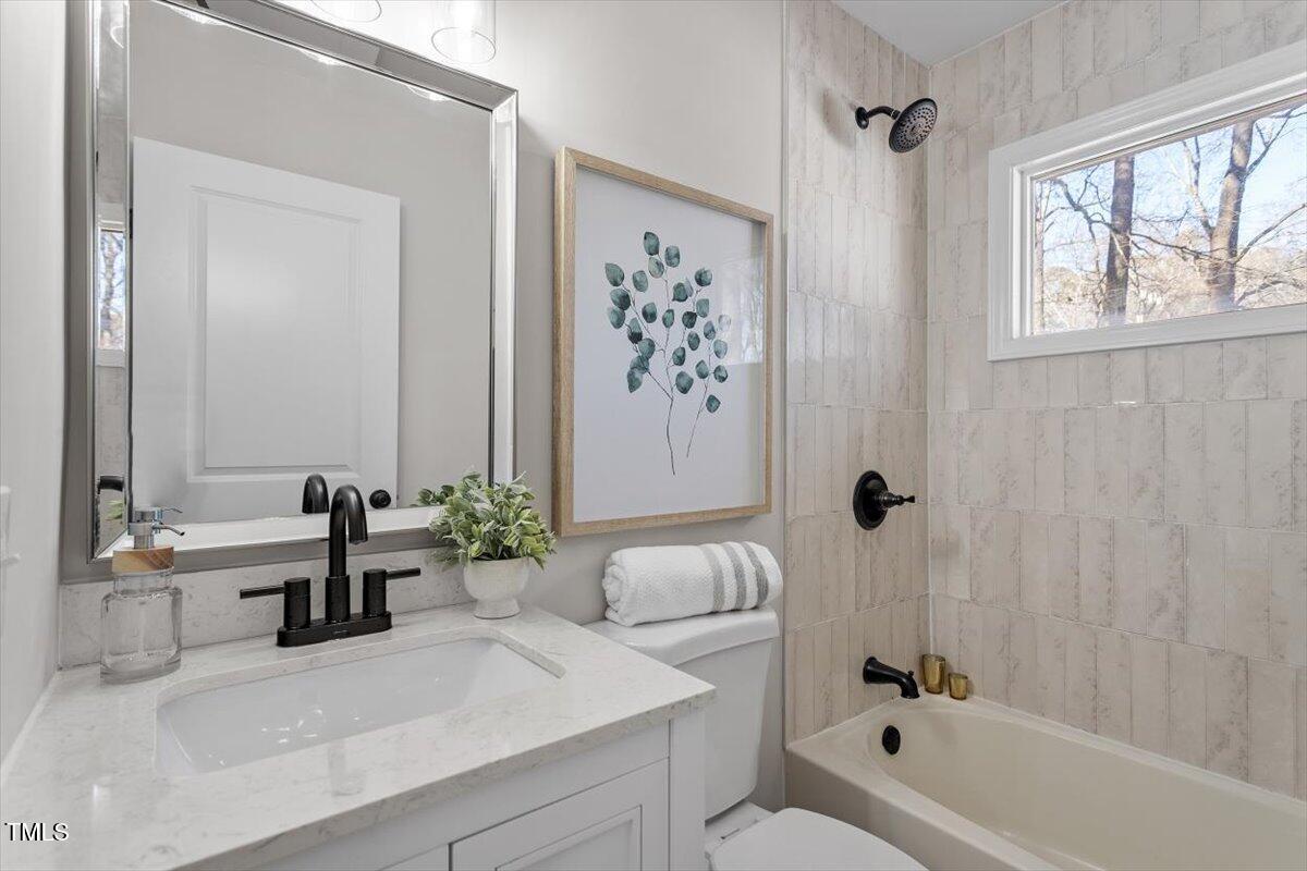 1404 Valley Road Garner, NC 27529 - Photo 8 of 29 a bathroom with a tub sink and mirror