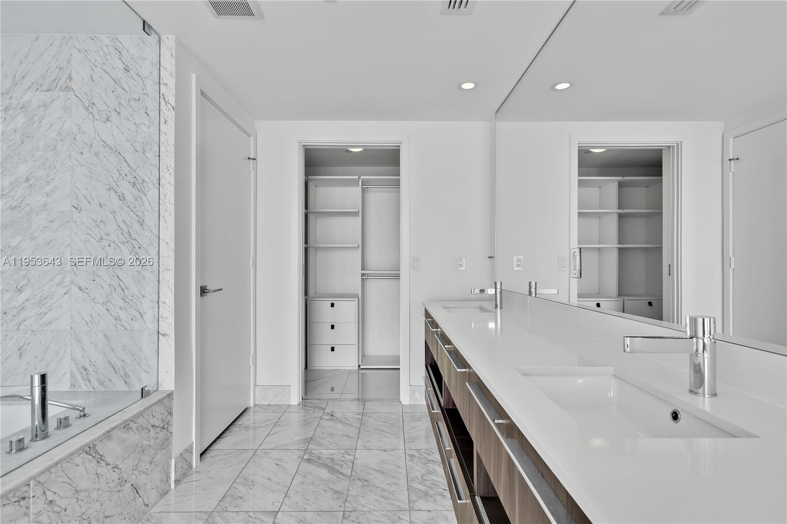 3131 Northeast 7th Avenue, Unit 3704 Miami, FL 33137 - Photo 27 of 61 a spacious bathroom with a double vanity sink a mirror and a bathtub