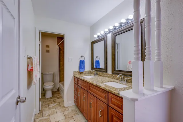 a bedroom with a bed and a large mirror on the dresser
