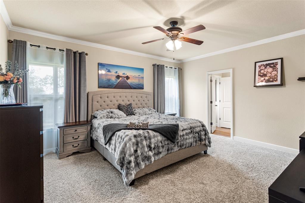 223 Cottongame Road Weatherford, TX 76088 - Photo 18 of 39 a bedroom with a bed and a chandelier