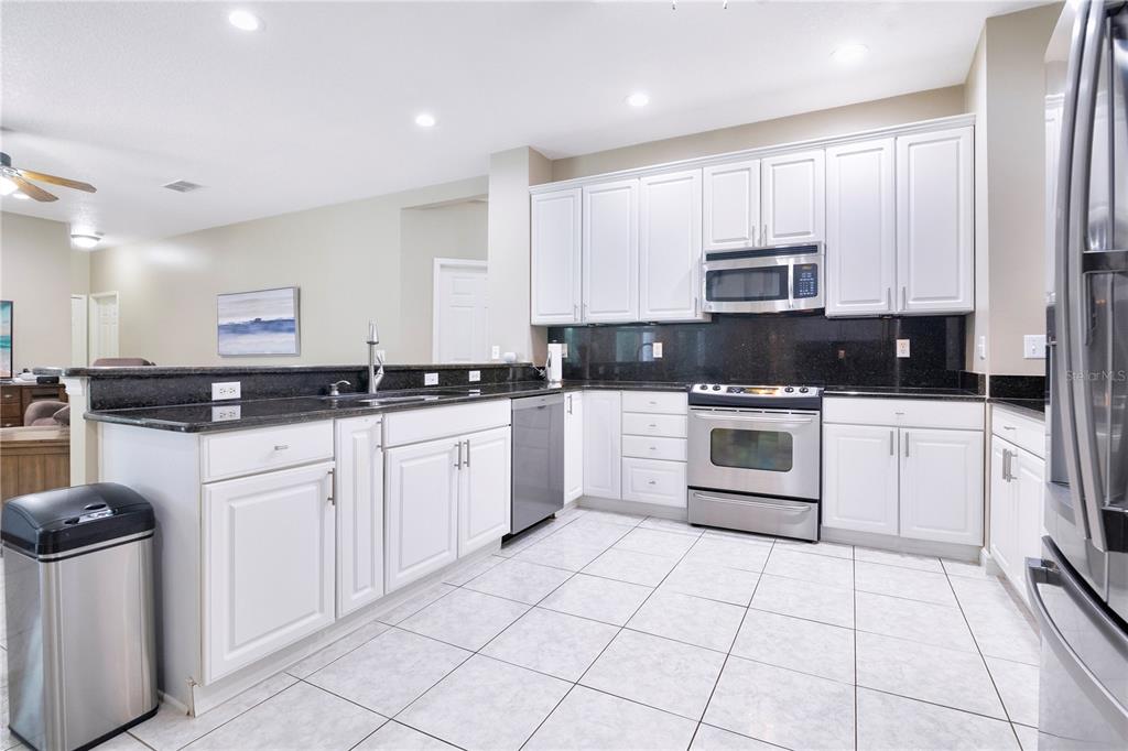 10216 Trout Road Orlando, FL 32836 - Photo 7 of 33 a kitchen with white cabinets sink and white appliances