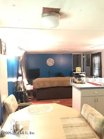 a kitchen with granite countertop white cabinets and a stove with wooden floor
