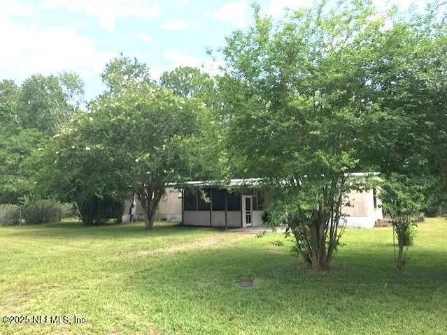 a view of a backyard with a garden and trees