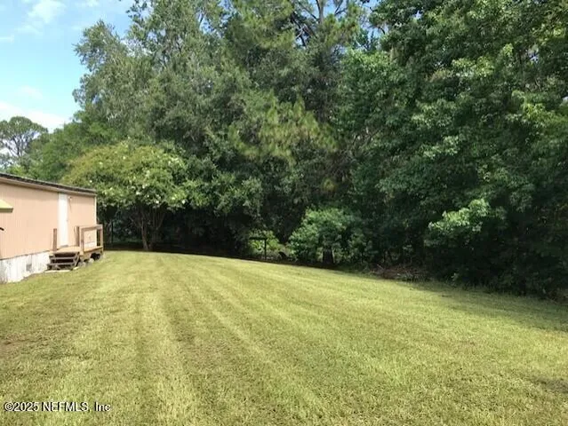 a view of backyard of house and car parked