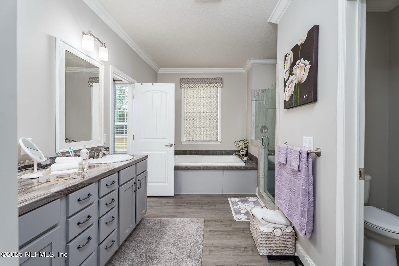 6529 County Road 121 Bryceville, FL 32009 - Photo 16 of 39 a spacious bathroom with a double vanity sink a mirror a bathtub and window