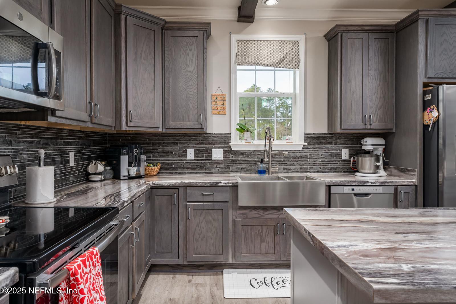 6529 County Road 121 Bryceville, FL 32009 - Photo 10 of 39 a kitchen with stainless steel appliances granite countertop a stove a sink and a microwave