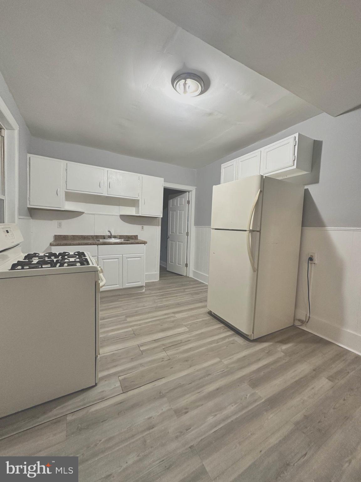 1109 Nottingham Way Hamilton, NJ 08609 - Photo 5 of 17 a kitchen with a refrigerator a stove top oven and white cabinets