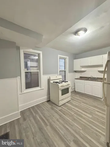 a view of kitchen with stove top oven and cabinets