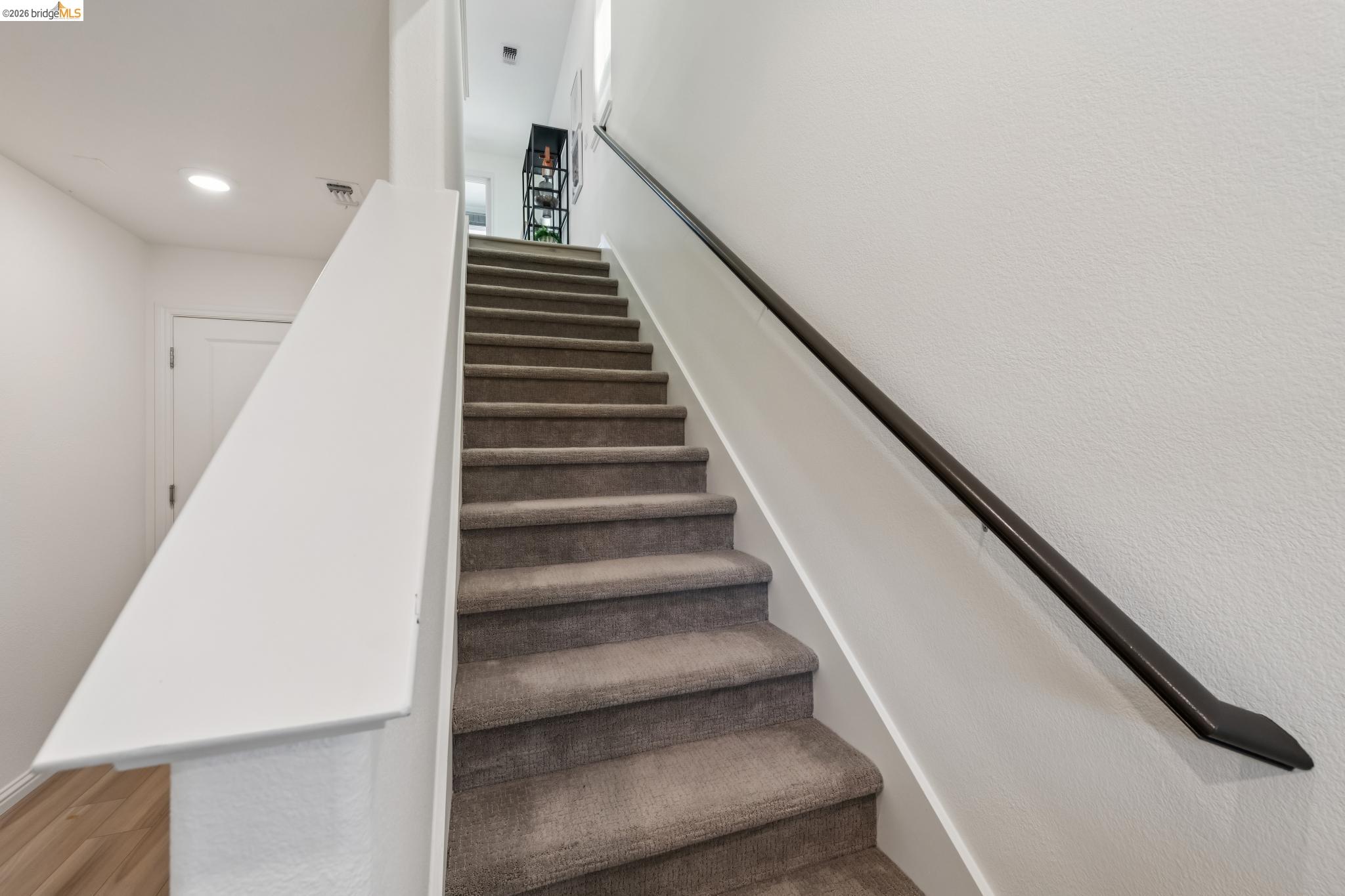 24157 Amaranth Loop Hayward, CA 94541 - Photo 14 of 63 Carpeted staircase with a dark-finish wall-mounted handrail