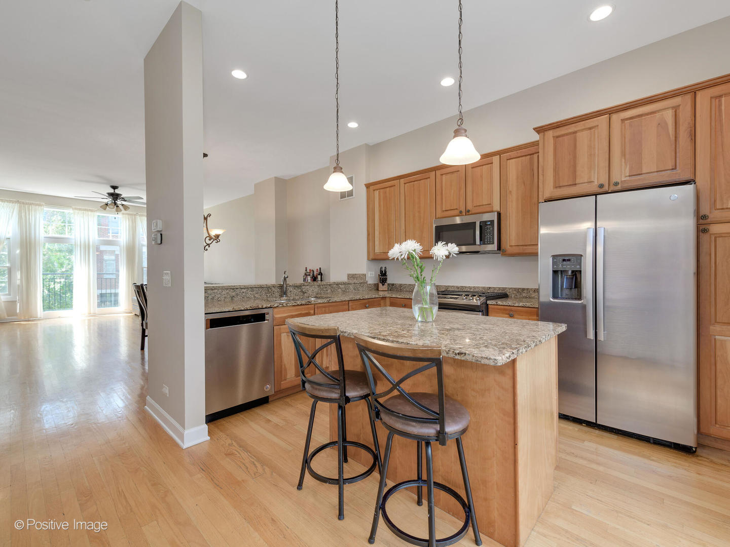 855 North May Street, Unit E Chicago, IL 60642 - Photo 9 of 30 a kitchen with kitchen island a refrigerator a stove a sink and white cabinets with wooden floor