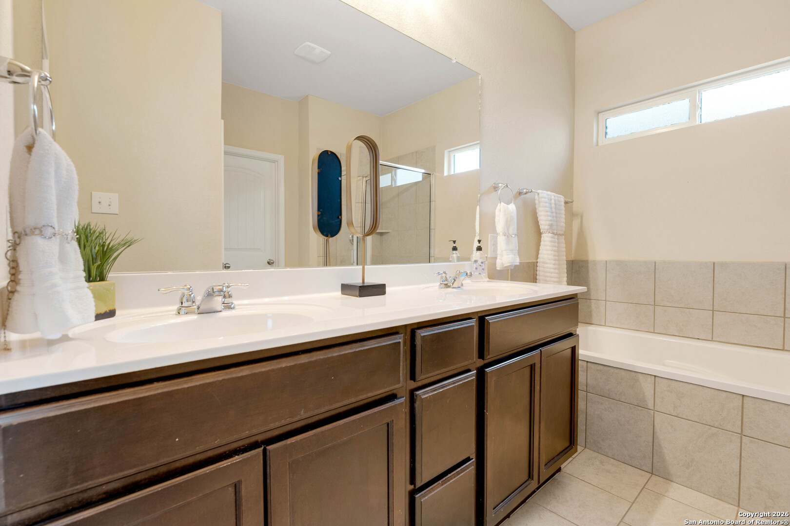 428 Kings Way Cibolo, TX 78108 - Photo 15 of 30 a bathroom with a double vanity sink a mirror and a bathtub
