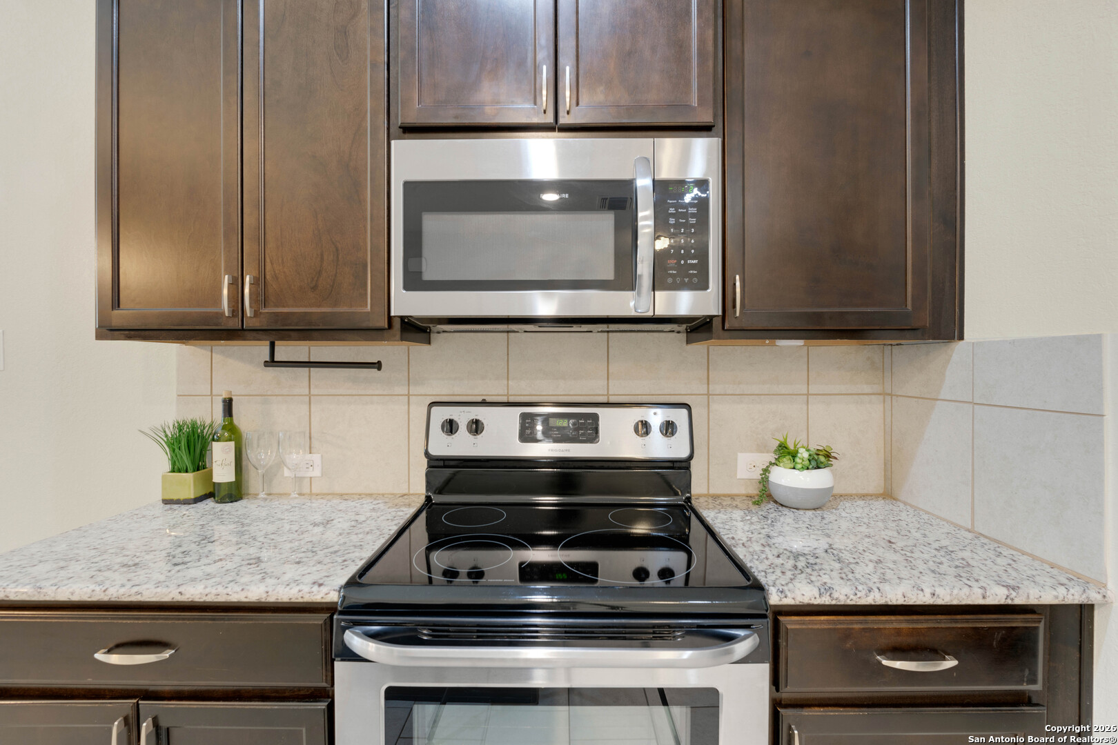 428 Kings Way Cibolo, TX 78108 - Photo 7 of 30 a kitchen with granite countertop a stove top oven microwave and cabinets