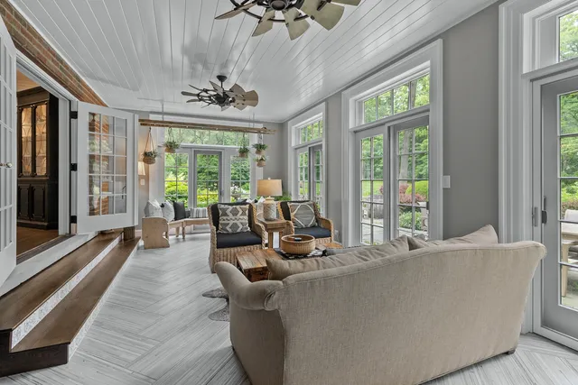 a living room with furniture and floor to ceiling windows
