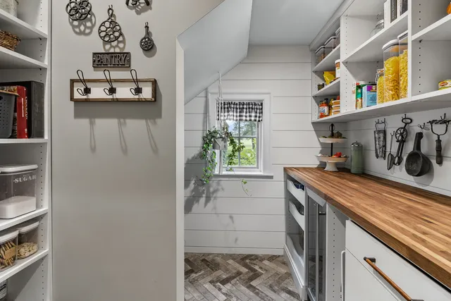a hallway with a stove a microwave and a potted plant