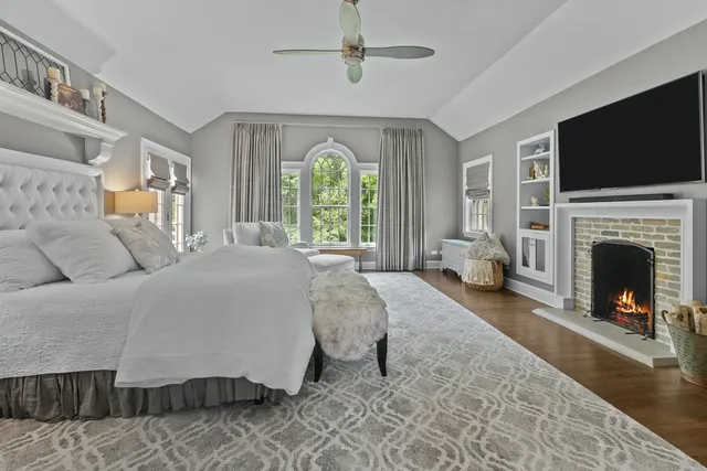 a spacious bedroom with a bed and a flat screen tv