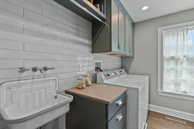 a utility room with cabinets washer and dryer