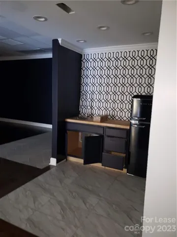a kitchen with a wooden floor and black wall painting