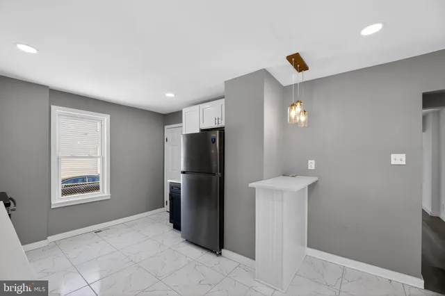 a view of kitchen with furniture and refrigerator