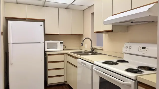 a view of a livingroom with wooden floor and a sink