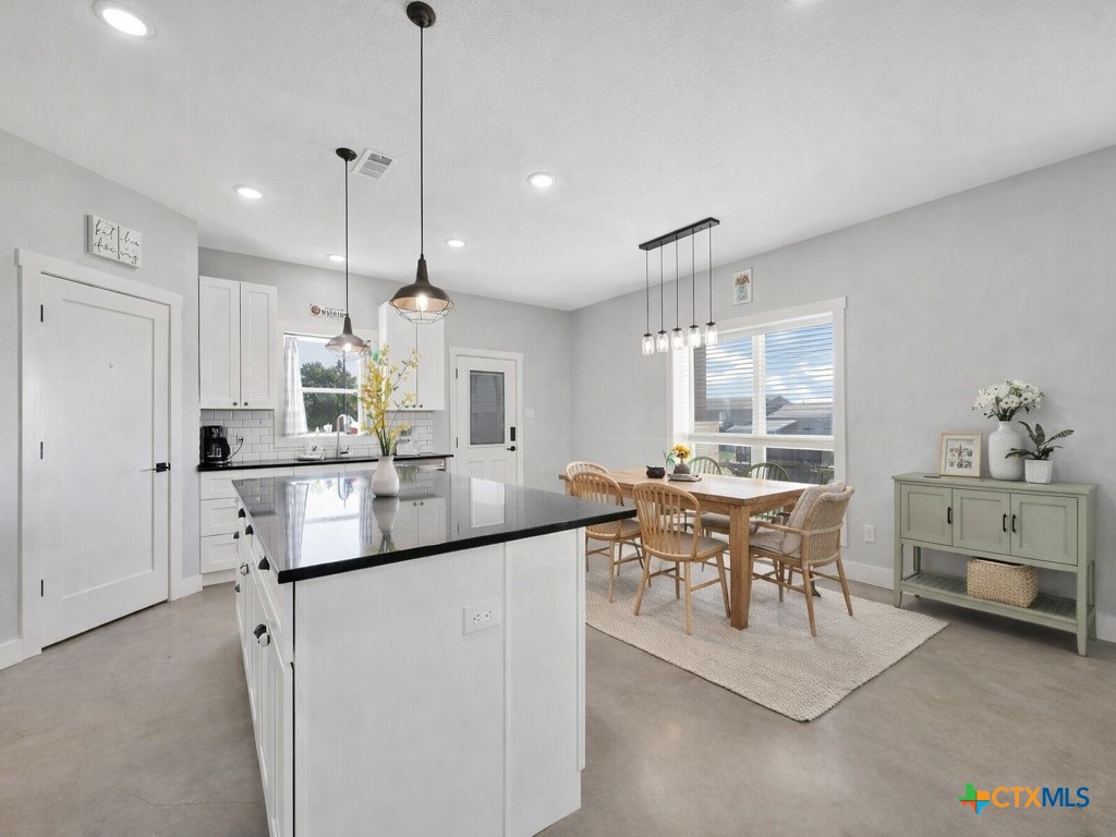 6887 Smith Dairy Road Belton, TX 76513 - Photo 12 of 48 a kitchen with kitchen island cabinets and white appliances