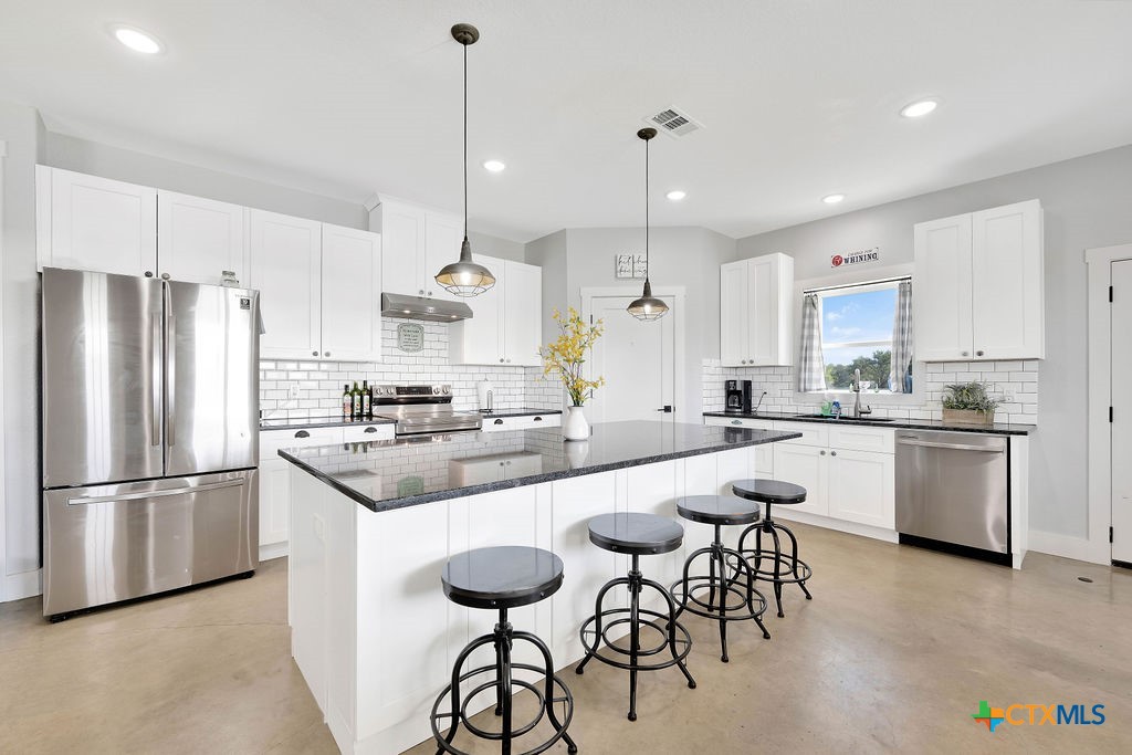 6887 Smith Dairy Road Belton, TX 76513 - Photo 15 of 48 a kitchen with white cabinets and stainless steel appliances