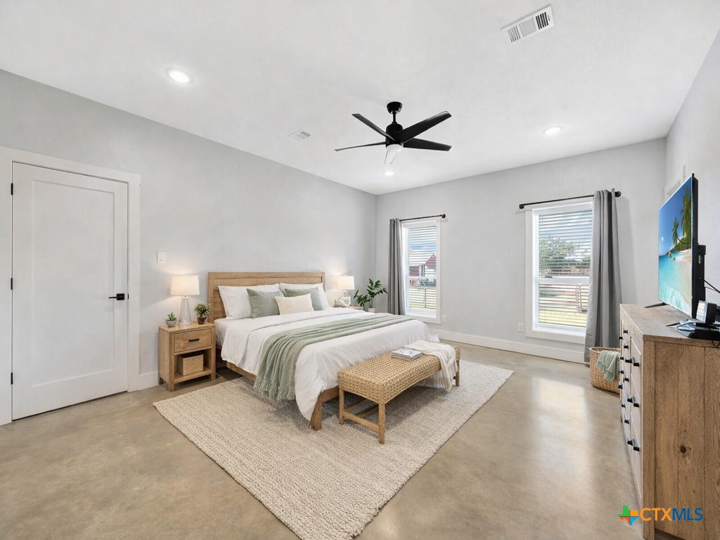 6887 Smith Dairy Road Belton, TX 76513 - Photo 2 of 48 a spacious bedroom with a bed and a chandelier
