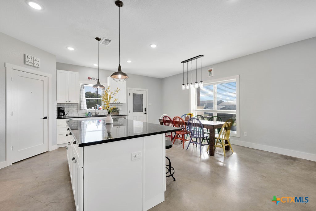 6887 Smith Dairy Road Belton, TX 76513 - Photo 22 of 48 a kitchen with kitchen island stainless steel appliances a dining table and chairs