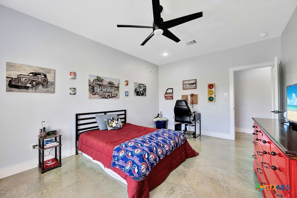 6887 Smith Dairy Road Belton, TX 76513 - Photo 29 of 48 a bedroom with a bed furniture and a chandelier