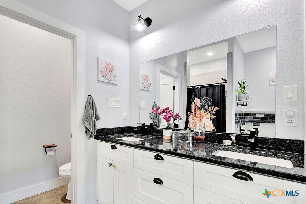 6887 Smith Dairy Road Belton, TX 76513 - Photo 6 of 48 a bathroom with a double vanity sink mirror and toilet