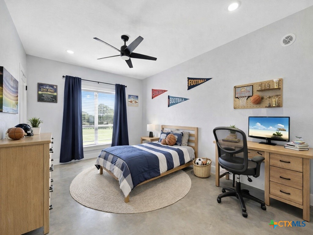 6887 Smith Dairy Road Belton, TX 76513 - Photo 10 of 48 a bedroom with a bed and a chandelier