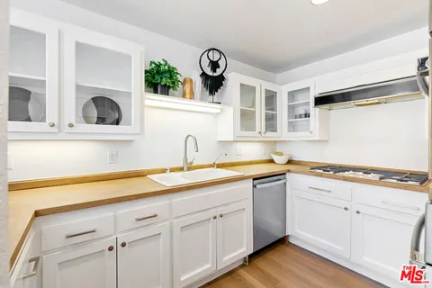 a kitchen with a sink cabinets and wooden floor