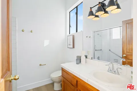 a bathroom with a sink vanity granite and toilet