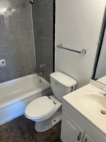 a white toilet sitting next to a bath tub and a shower