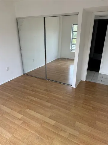 a view of a big room with wooden floor and windows
