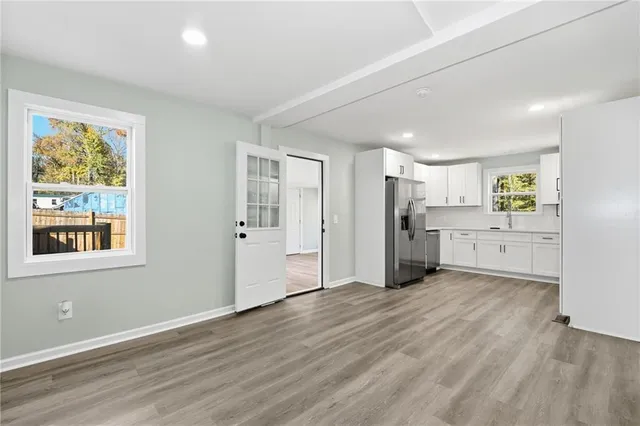 an empty room with wooden floor and windows