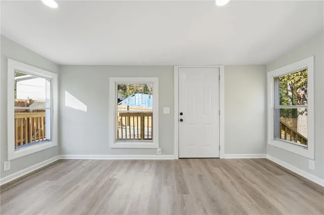 an empty room with wooden floor and windows