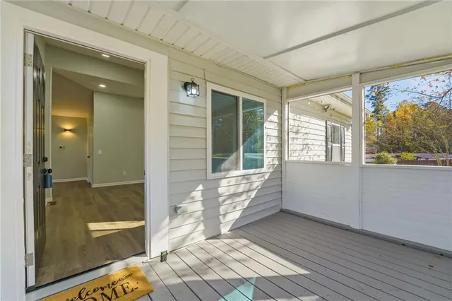 a view of an empty room with wooden floor fireplace and a window