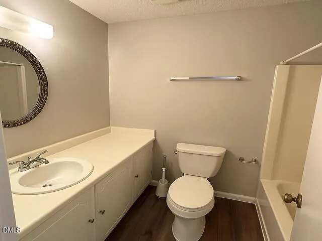 a bathroom with a granite countertop toilet and a sink