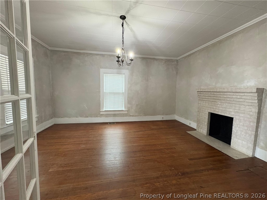 3174 Lindsay Road Raeford, NC 28376 - Photo 6 of 28 a view of empty room with wooden floor fireplace and window