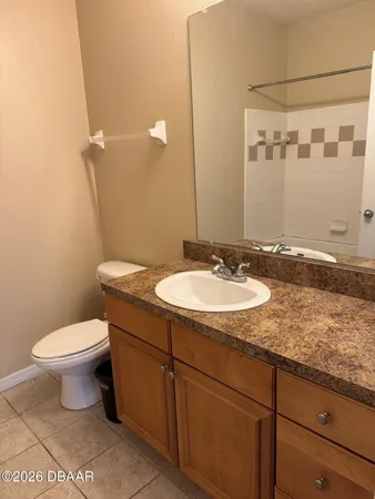 a bathroom with a granite countertop sink toilet and a mirror
