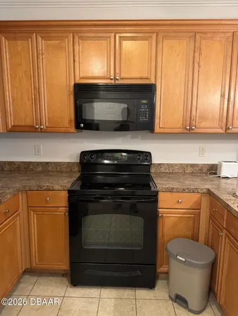 a kitchen with granite countertop a stove top oven microwave and cabinets