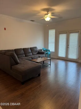 a living room with furniture and a wooden floor