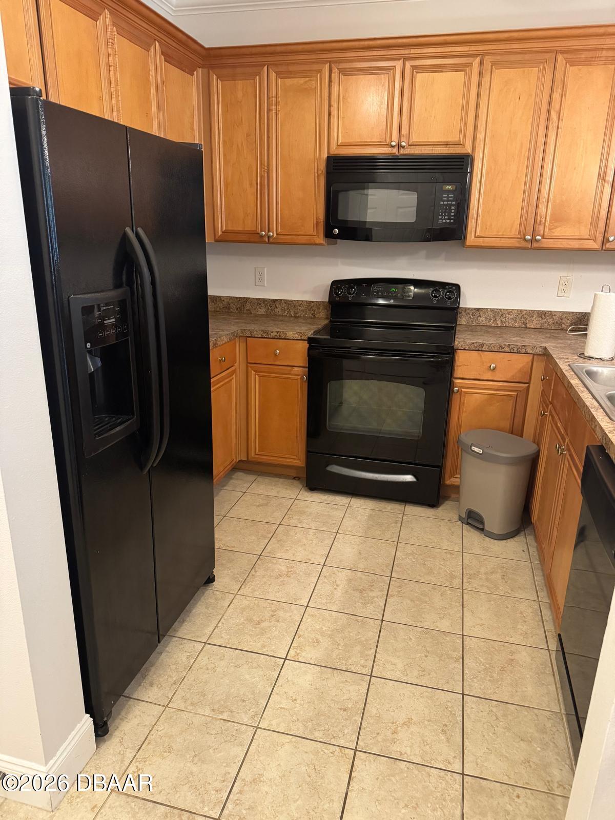 1185 Southwest 9th Road Gainesville, FL 32601 - Photo 8 of 25 a kitchen with a refrigerator a stove top oven a sink and cabinets