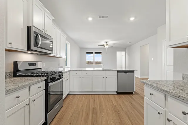 a kitchen with granite countertop a sink and a stove top oven