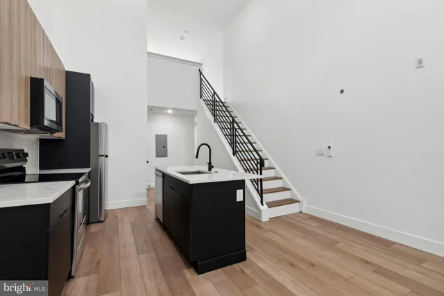 a view of kitchen with sink microwave and refrigerator