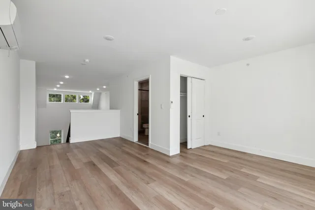 a view of a livingroom with wooden floor and kitchen