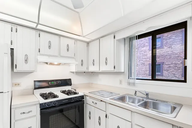 a kitchen with granite countertop a sink stove and cabinets