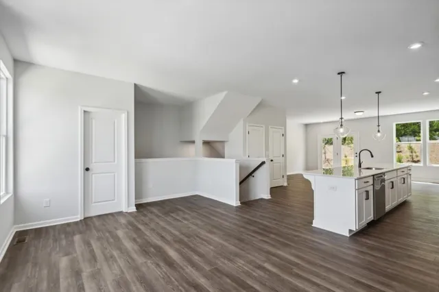 a large white kitchen with wooden floors and white walls
